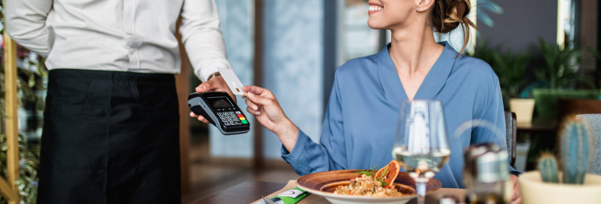 Junge Dame zahlt mit Karte im Restaurant