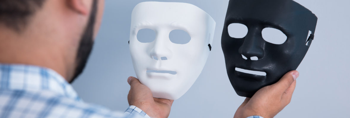 Mann hat schwarze und weiße Maske in der Hand