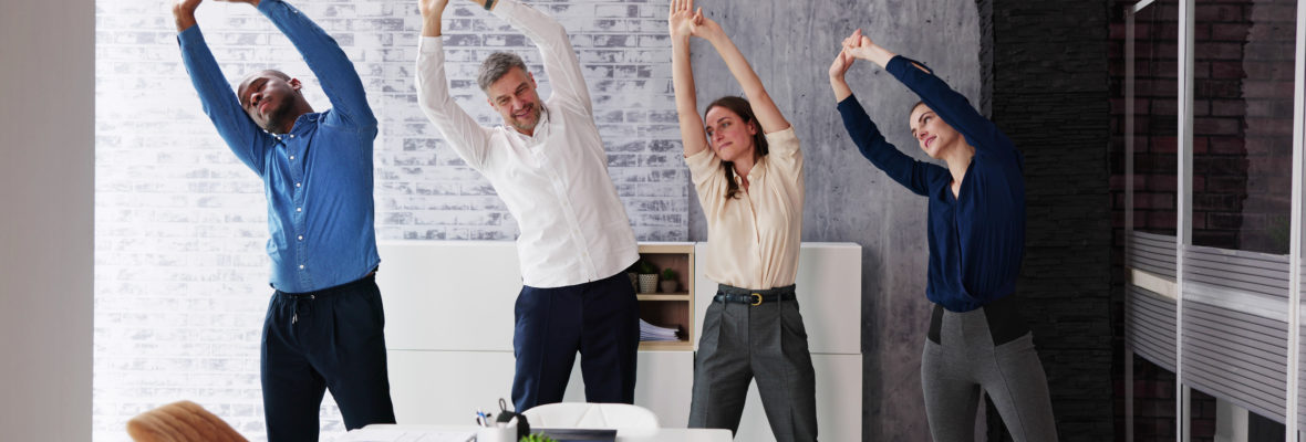 Dehnübungen von vier Personen im Büro