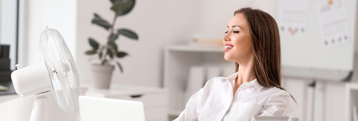 Frau im Büro mit Ventilator