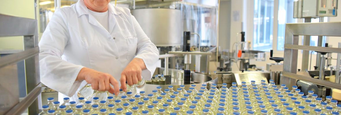 Produktion von Impfdosen // medical products manufacturing in a modern factory - glass bottles with medications on conveyor belt