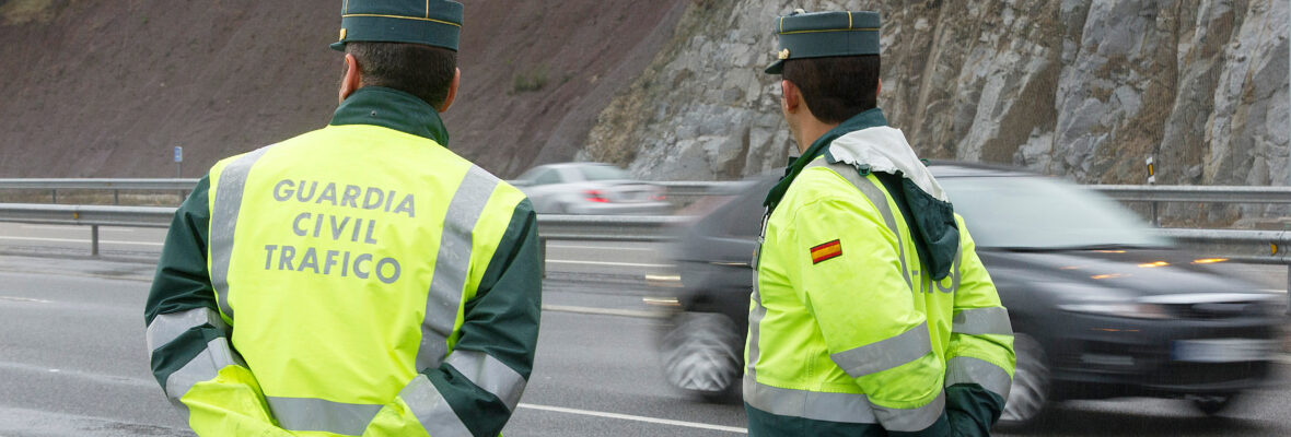 Beamte der Guardia Civil beobachten den Verkehr auf einer Autobahn an einem regnerischen Tag.
