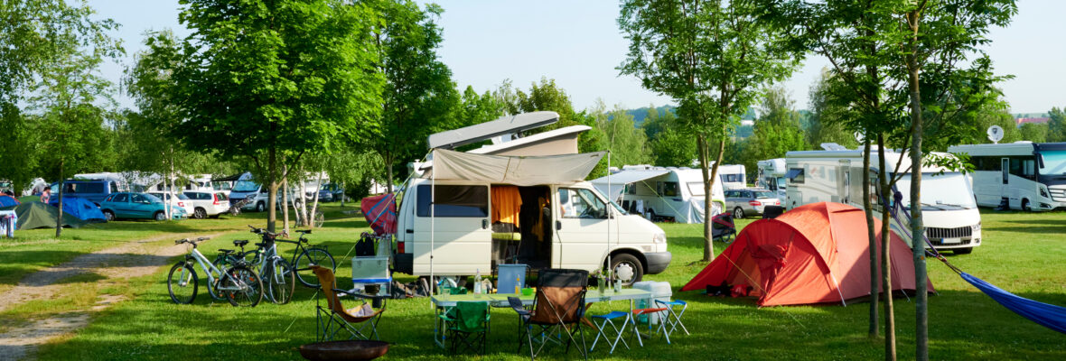 Wohnmobil auf Campingplatz in Deutschland mit Zelt.