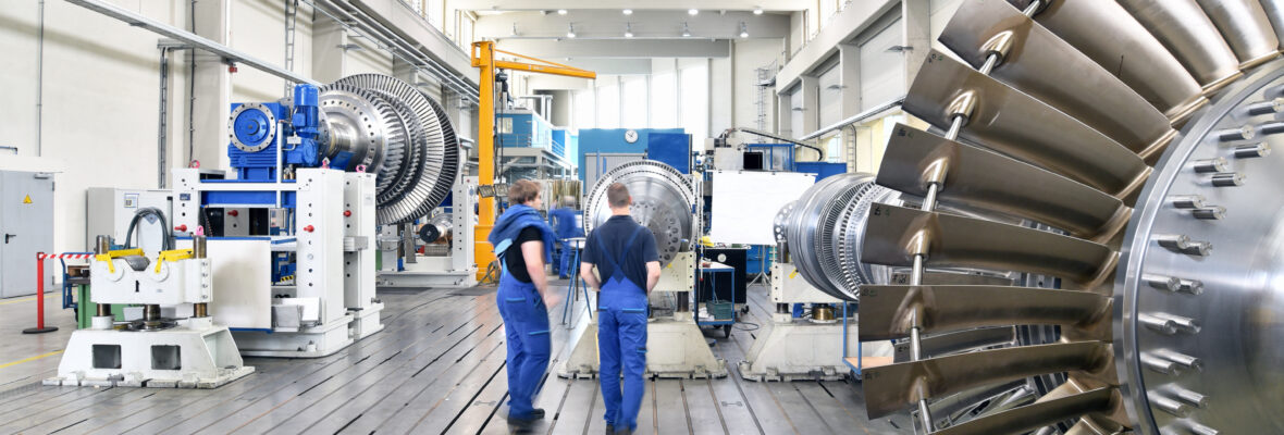 Zwei Arbeiter in einer Industriehalle.