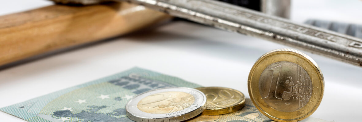 Bargeld (in Euro) liegt vor Hammer und Schraubenschlüssel