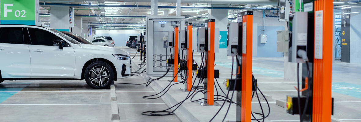 Ein E-Auto steht in einer Garage und lädt seinen Akku. In der Tiefgarage sind zahlreiche E-Ladesäulen für Autos.